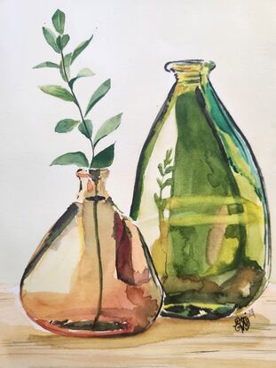 2 glass bottles with a stem of leaves.