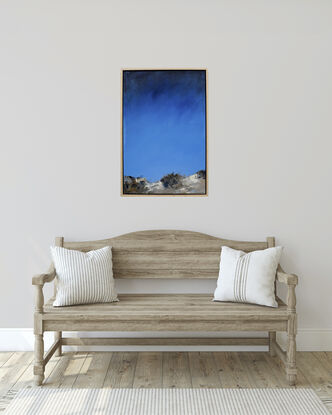 Intense blue sky, low horizon, beach sand dunes in the foreground with bush scrub.