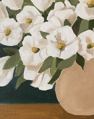 White flowers in a beige vase on a warm background.