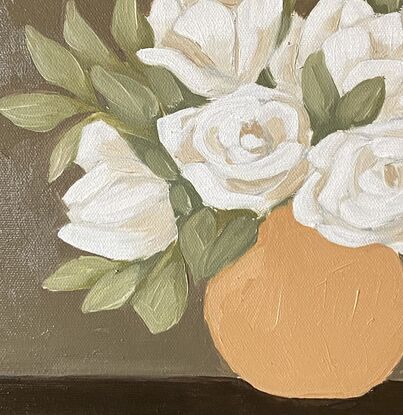 White flowers in a mustard vase on a warm background.