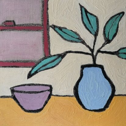 Eucalyptus leaves in a blue vase, next to a red bowl.