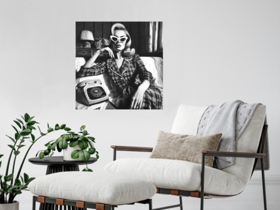 High contrast portrait of a beautiful 1950s woman in pyjamas sitting on a midcentury sofa with a phone beside her.