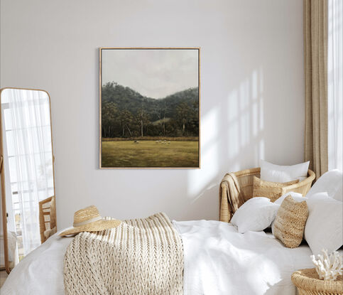 Flock of sheep in the foreground of a dramatic Australian landscape dense with gum trees.