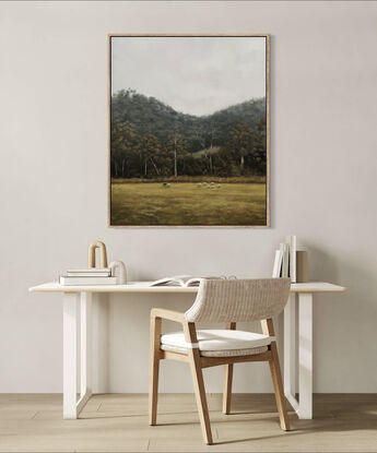 Flock of sheep in the foreground of a dramatic Australian landscape dense with gum trees.