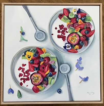 Two bowls of yogurt and fruit, adorned with pansies. 