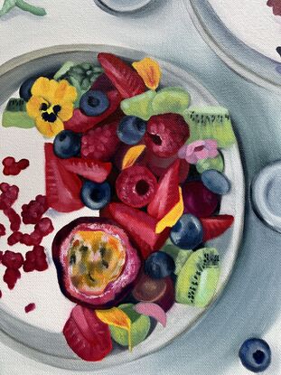 Two bowls of yogurt and fruit, adorned with pansies. 