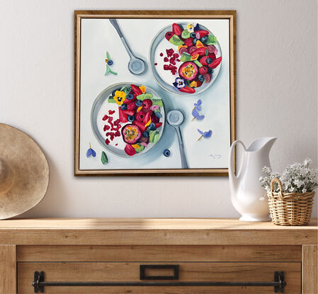 Two bowls of yogurt and fruit, adorned with pansies. 