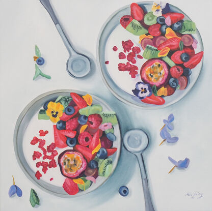 Two bowls of yogurt and fruit, adorned with pansies. 