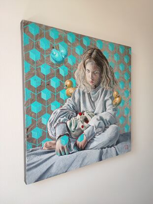 A boy with long blond hair is sitting on a bed. He holds a mask and stares in front of him. Three rubber ducks are levitating around him. The background features a geometric pattern.