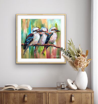 Three kookaburras sitting on a branch, painted in a colourful style.