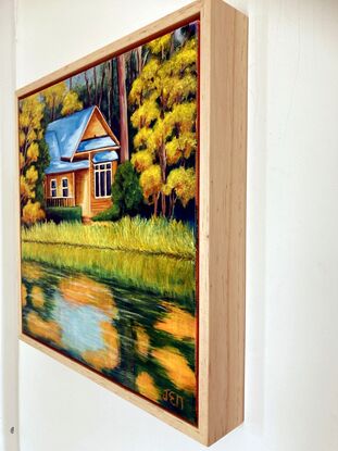 This weatherboard cottage sits beside the lake at ECU's Joondalup campus. The building and trees are imagined in autumn tones and the waters of the lake reflect the beautiful yellow, orange and blue colours of autumn.