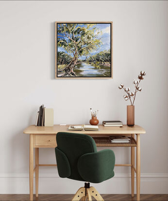 A swaying gumtree leans across the Murray River. The blue sky is reflected in the water. 