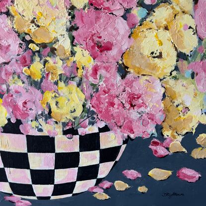 Bright Pink Yellow  flowers bursting in full bloom in a black checkered bowl or vase