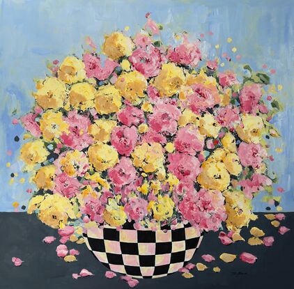 Bright Pink Yellow  flowers bursting in full bloom in a black checkered bowl or vase