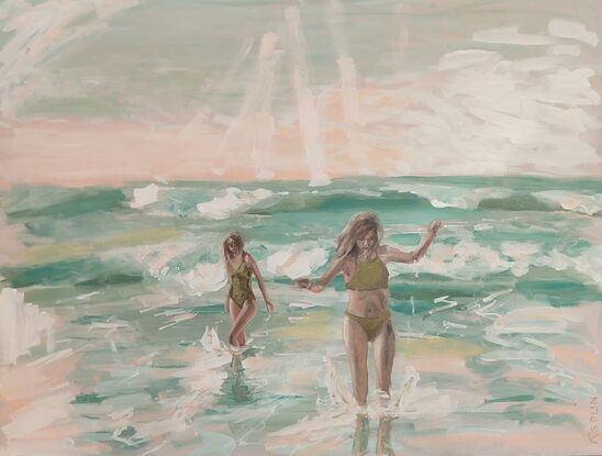 Two young women wade through waves.