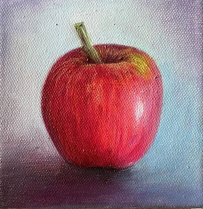 A small painting of a red apple with a blue background on a framed canvas.