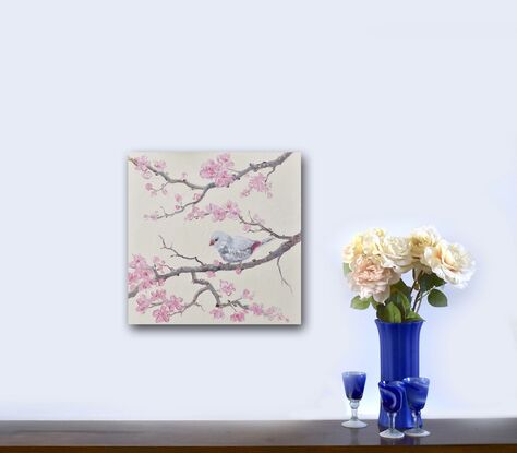 A thickly textured oil painting of a Silver Diamond Firetail Finch perched on a branch of pink Japanese Cherry Blossom. The small bird is a pale silver colour with red on its tail.