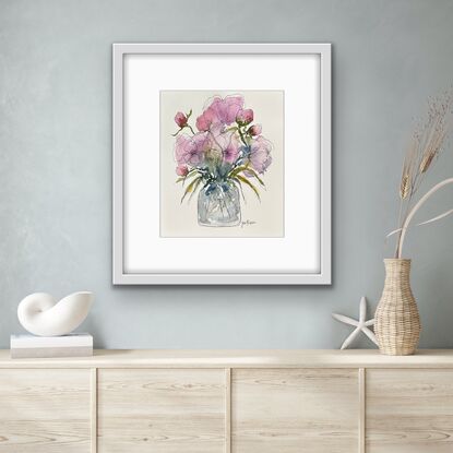 A bouquet of soft pastel roses and buds in pink and mauve in a glass vase