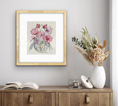 A bouquet of soft pastel flowers in pink and mauve in a round glass vase