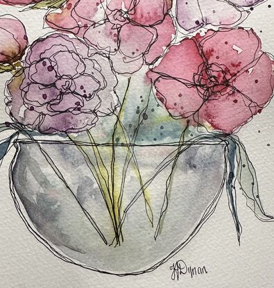 A bouquet of soft pastel flowers in pink and mauve in a round glass vase