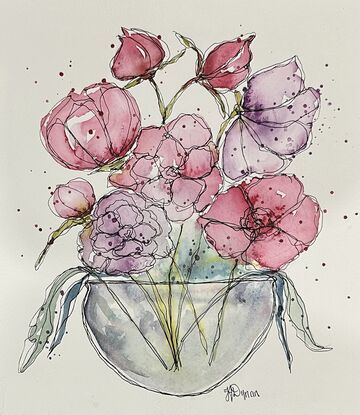 A bouquet of soft pastel flowers in pink and mauve in a round glass vase