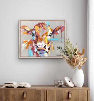 Portrait of a cow on a neutral gray background with pops of colour in the face of the cow. 