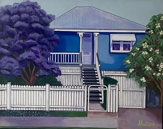 Typical blue Queenslander style home found in Brisbane. It is surrounded by. frangipani tree and a Jacaranda tree common in Brisbane. All neatly behind a white picket fence. 