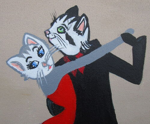 A black cat and a grey cat in costume doing the tango.