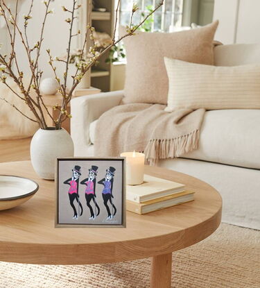 Three black cats in top hats and glittering costumes doing a vaudeville dance