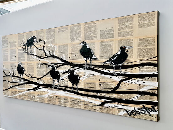 magpies sitting on a branch on book pages