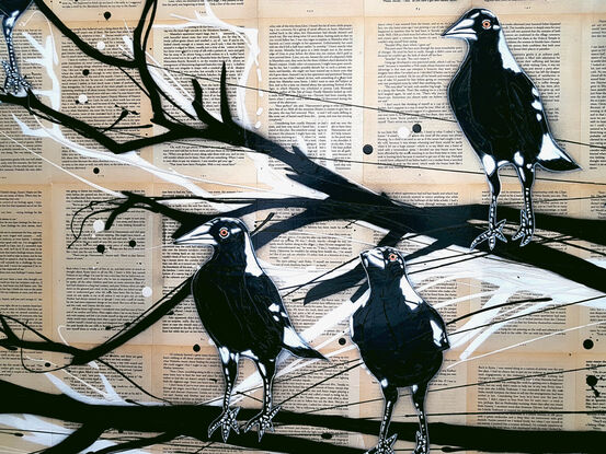 magpies sitting on a branch on book pages