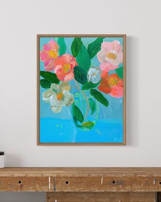 Pink red white camellias in glass vase with blue background. Relaxing and peaceful scene 