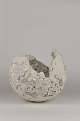 All white concrete sculpture with quartz rocks, that looks like a illuminated deserted planet.