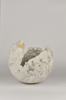 All white concrete sculpture with quartz rocks, that looks like a illuminated deserted planet.