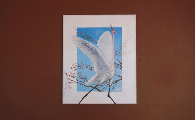 A painting of a white crane in mid-flight with wings outstretched, set against a vibrant blue background. The bird is surrounded by branches adorned with delicate pink blossoms, creating a serene and elegant composition.