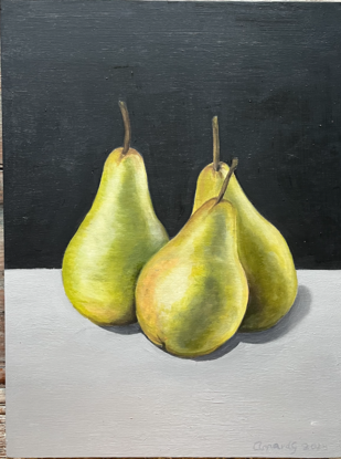 Three green pears on a bench top 