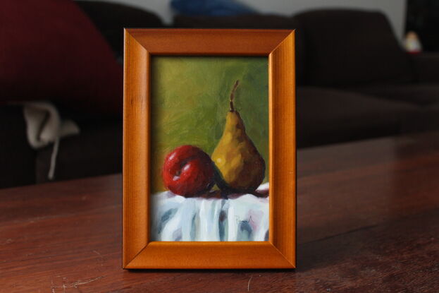 Red apple and yellow pear on table.