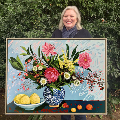 A still life painting of flowers and fruit in blues, reds, oranges, yellows, whites, pinks and greens, framed in oak