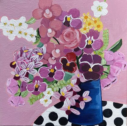 Small painting with flowers in blue vase on polka dot tablecloth 