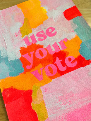 abstract acrylic painting with vibrant colours with the text "use your vote" front and centre, in pink.