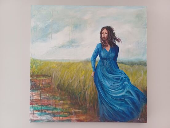 Woman in blue dress walking in open plain near wetlands