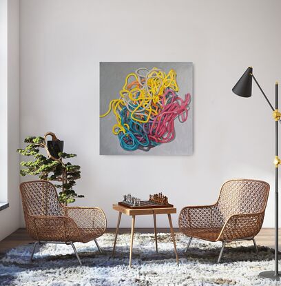 A birds eye view of a colourful pile of woollen threads on a grey background.