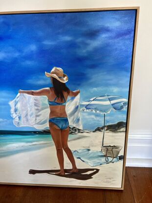 Women shaking out a towel on a beach. 