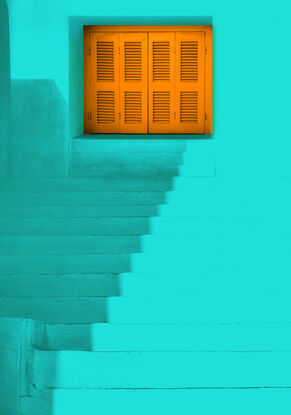 White steps with gold coloured shutters  on a narrow walkway in the Chora on the island of Amorgos in Greece.