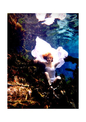 Enchanting underwater scene with a girl in a flowing white dress, submerged amidst aquatic plants.