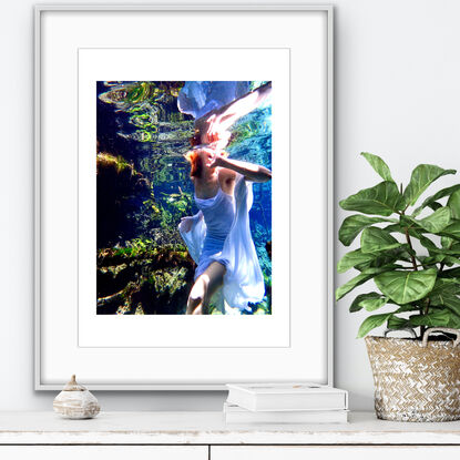 A vibrant underwater scene featuring a girl in a flowing white dress.