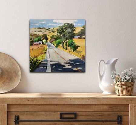 Rural Australian Landscape depicting a road with trees and rolling hills in the background.