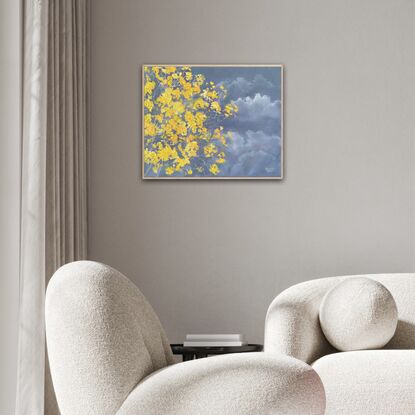 A partial view of the Silver Trumpet tree in full bloom against a stormy sky. Bright yellow flowering tree.