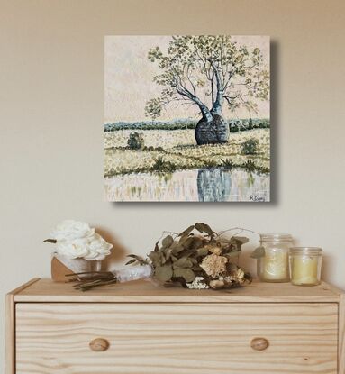 Bottle or boab tree in a rural setting with a light pink sky near a waterhole, with reflections in water. 