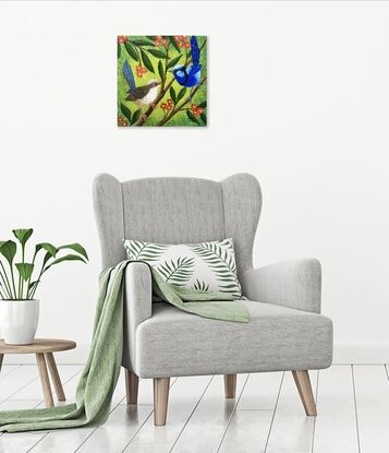 Two blue wrens, a male and a female, sitting in a tree surrounded by leaves and orange flowers. The background is a yellow-greenish colour which contrasts nicely with the blue of the birds and the orange flowers. The colour is wrapped around the sides of the canvas.